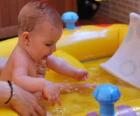 Девочка купается в небольших надувных бассейна